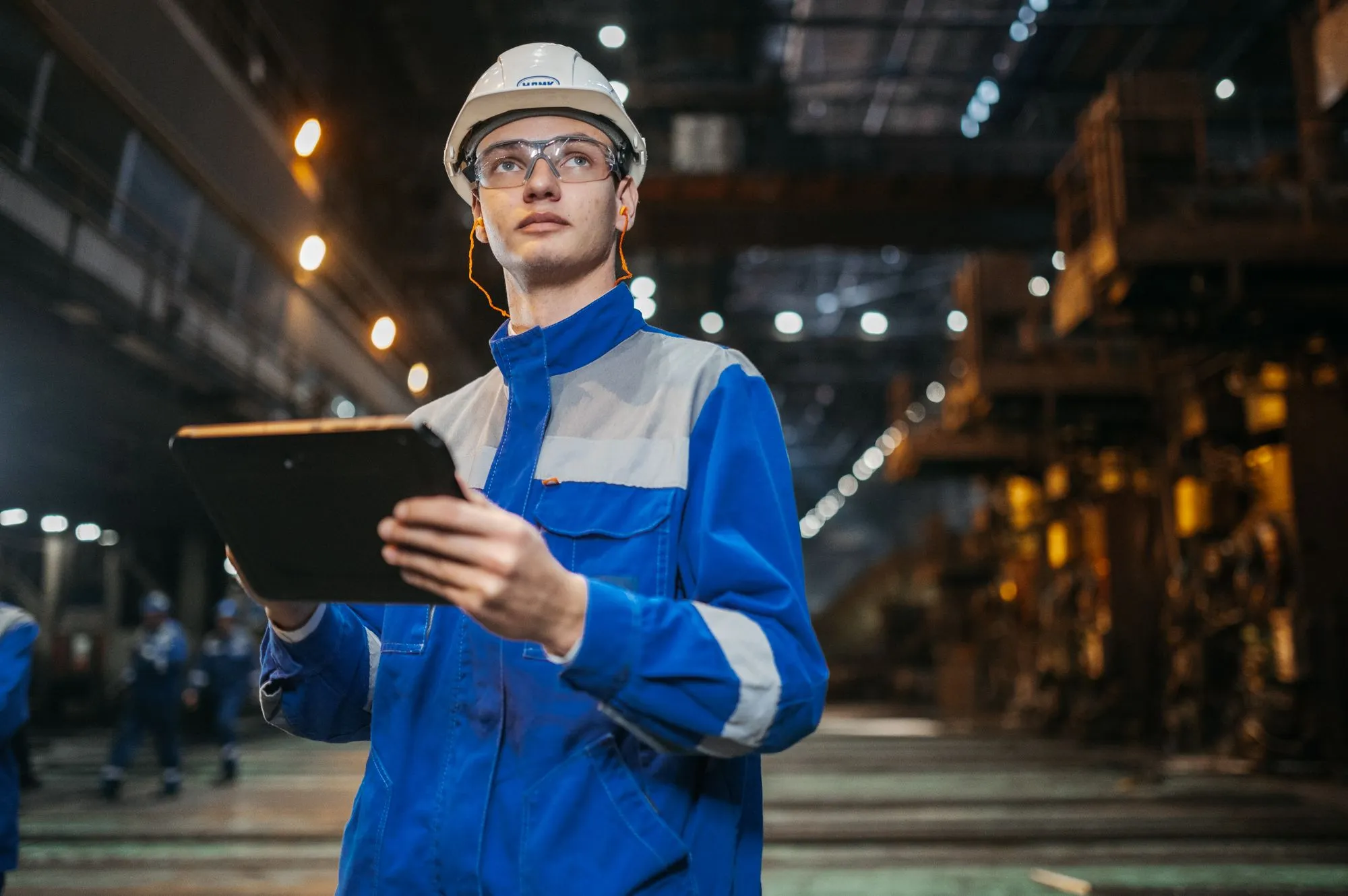 Ingenieur mit Klemmbrett bei der Abnahme in einer technischen Anlage