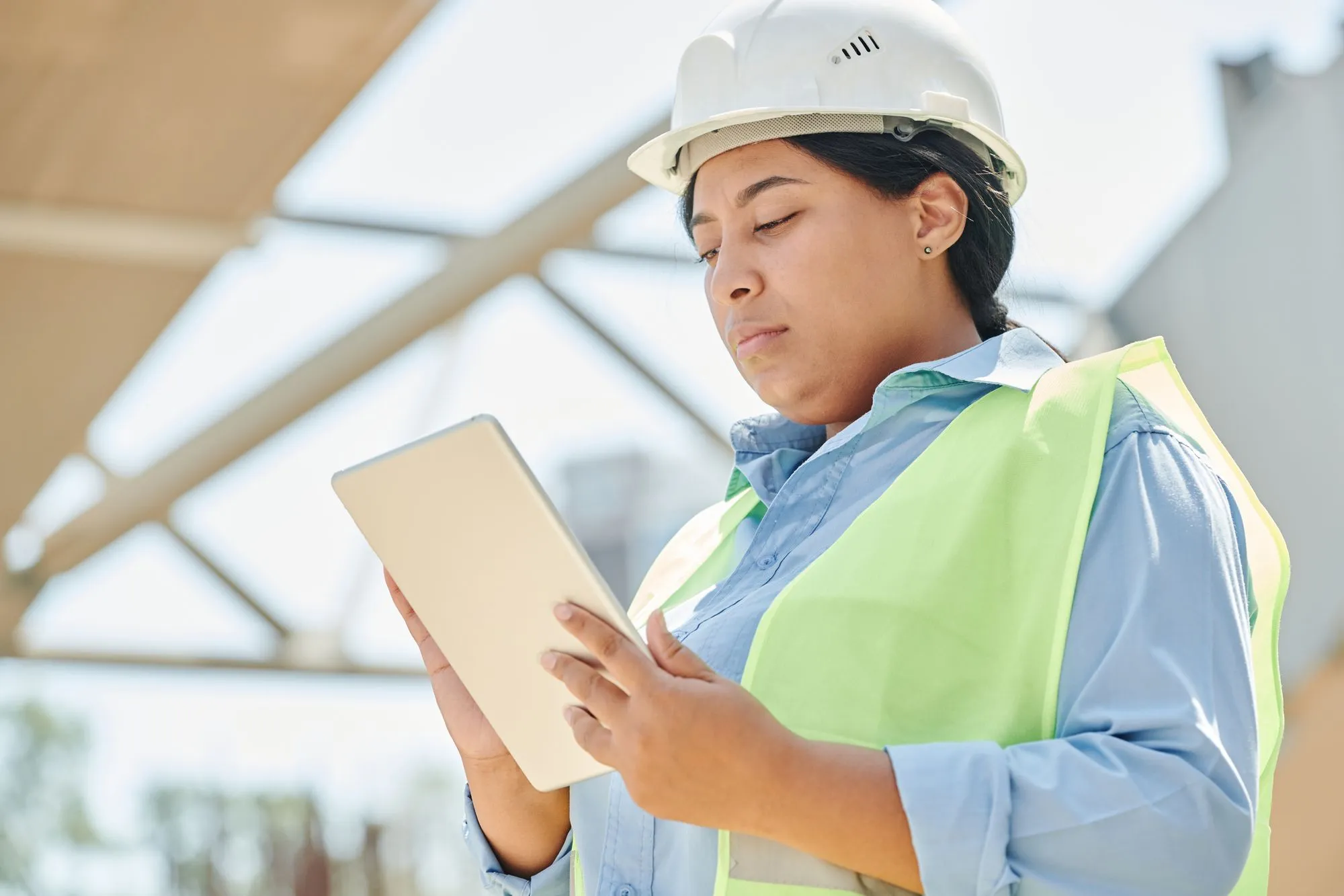 Ingenieurin mit Schutzhelm dokumentiert auf dem Tablet